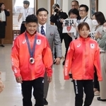 多くの市職員に拍手で迎えられた玉井陸斗さん（中央左）と荒井祭里さん（同右）。寺内健さん（中央）も出席した＝宝塚市役所