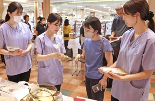 食材をポリ袋に入れて調理する「パッククッキング」を紹介する甲南女子大学の学生ら＝西宮市北口町