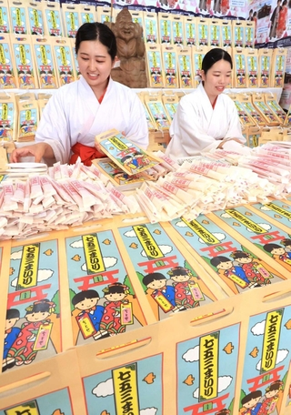 千歳あめなどの袋詰め作業を進める巫女たち＝西宮市社家町