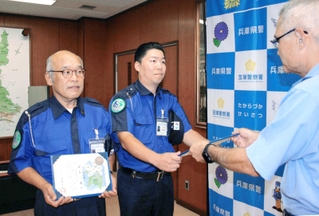 石井克央・宝塚署長（右）からのじぎく賞を受け取る倉本一義さん（左）と三谷好弘さん＝宝塚署