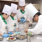 ホテル日航プリンセス京都の中埜智史総料理長（右）から指導を受ける生徒ら＝尼崎市開明町２