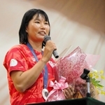 生徒から贈られた花束を手に話す吉岡美帆選手＝県立芦屋高校