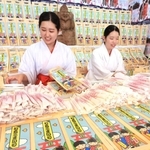 千歳あめなどの袋詰め作業を進める巫女たち＝西宮市社家町