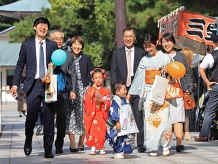 晴天の下、にこやかに参道を歩く七五三参りの家族＝西宮市社家町