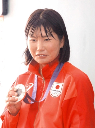 母校の児童たちに銀メダルを見せ、世界の舞台での活躍を報告する吉岡美帆選手＝西宮市東山台２