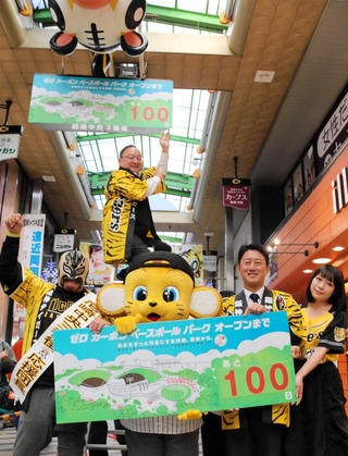 阪神タイガース２軍球場オープン１００日前を記念しカウントダウンボードを掲げる商店主ら＝尼崎市神田中通３