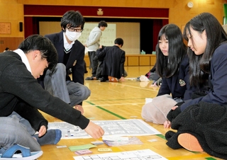 防災ジュニアリーダーに見守られながら、ボードゲームを体験する生徒ら＝川西市萩原台西２、川西明峰高校