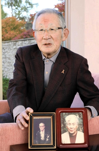 両親の写真を手に語る清水將之さん＝神戸市東灘区
