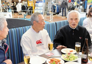 後輩たちと談笑する堀江謙一さん（右）＝西宮市西宮浜４、新西宮ヨットハーバー