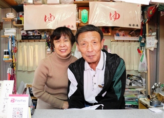 川西市で唯一の銭湯「極楽湯」を守る店主の濵谷康晴さん（右）と妻の裕美子さん＝川西市中央町