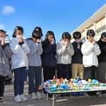 冬休みに折った紙の花を供え、祈りをささげる児童ら＝１７日午前９時５３分、芦屋市精道町、精道小学校（撮影・吉田敦史）