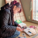 母の遺品整理で見つかった写真を確認する下野縫子さん＝２０２４年１１月、川西市（スリーマインド提供）
