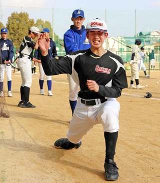 ゴムひもで引っ張られながら、投球動作を繰り返す中学生（手前）＝伊丹市奥畑３、伊丹西高