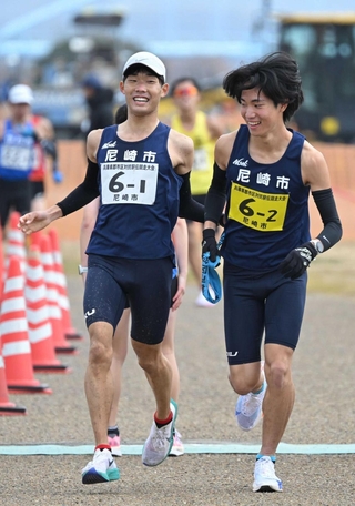 男子・尼崎市の１区山下慶馬選手（左）からたすきを受ける２区平野圭人選手＝加古川市の加古川河川敷マラソンコース（撮影・大田将之）