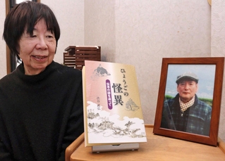 渋谷武弘さんの遺影と著書の「ひょうごの怪異」を眺める妻の悦子さん＝宝塚市寿楽荘
