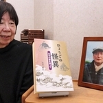 渋谷武弘さんの遺影と著書の「ひょうごの怪異」を眺める妻の悦子さん＝宝塚市寿楽荘