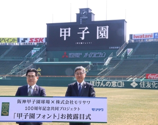 甲子園フォントでスコアボードに表示された「甲子園」の文字。モリサワの森澤彰彦社長（右）と阪神電鉄の谷本修取締役が披露した＝西宮市甲子園町、阪神甲子園球場