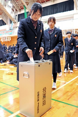 模擬の「校長選挙」で１票を投じる生徒＝尼崎市上ノ島町１