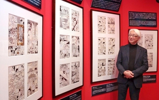 企画展の直筆原稿を眺める名誉館長の手塚真さん＝いずれも宝塚市武庫川町