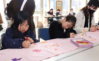 長い布に思い思いの絵を描く子どもら＝宝塚市栄町２