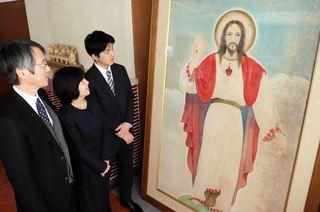 修復後の「キリスト像」を眺める（左から）楚良深さん、木下智香子さん、諒哉さん＝宝塚市塔の町