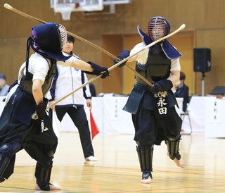 団体２回戦で、相手を果敢に攻める近畿大学付属豊岡高の永田歩実選手（右）＝伊丹市鴻池１