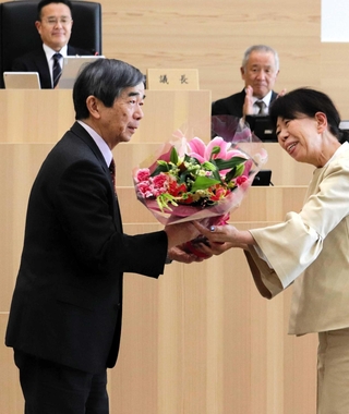議員から花束を受け取る藤原保幸市長（左）＝伊丹市議会議場