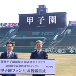 甲子園フォントでスコアボードに表示された「甲子園」の文字。モリサワの森澤彰彦社長（右）と阪神電鉄の谷本修取締役が披露した＝西宮市甲子園町、阪神甲子園球場