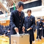 模擬の「校長選挙」で１票を投じる生徒＝尼崎市上ノ島町１