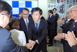 当選確実となり支援者らと握手を交わす中田慎也氏＝伊丹市中央４（撮影・吉田敦史）