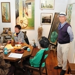 館内にはユタカ順子さんが描いた油絵の作品が並ぶ。右端が記念館を開いた阿部泰士さん＝西宮市甲子園六番町