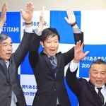 初当選が確実となり、藤原保幸市長（左）らと万歳して喜ぶ中田慎也氏＝伊丹市中央４（撮影・吉田敦史）