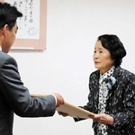 石井登志郎市長（左）から感謝状を受け取る女性＝西宮市役所