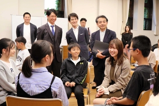 子どもたちが話し合う様子を見守る近本光司選手（奥左から２人目）と高島崚輔芦屋市長（同３人目）＝芦屋市打出小槌町