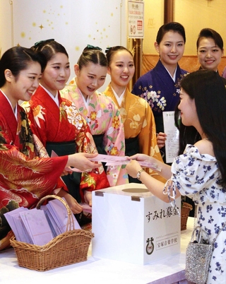 寄付した人にスミレ色のクリアファイルを手渡す生徒ら＝宝塚市栄町１
