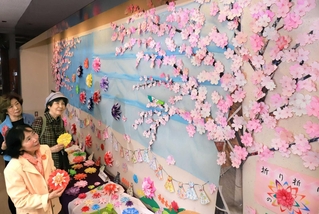 折り紙の桜やダリアで彩られた展示スペース＝宝塚市小浜４