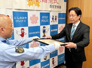署長感謝状を受け取る西宮高松郵便局の広畑裕康局長（右）＝西宮市津田町