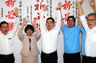 支援者とバンザイする永藤正明さん（中央）＝尼崎市富松町１（撮影・潮海陽香）