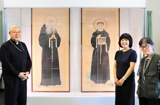 「日本二十六聖人画」２作品の里帰り展示を喜ぶ（左から）前田万葉枢機卿と木下智香子さん、岩波智代子浦上キリシタン資料館長＝大阪市中央区玉造２