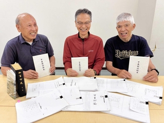 参考にした史料を前に、完成した甲東村誌稿本を手にする甲東文化財保存会メンバー＝西宮市甲東園３