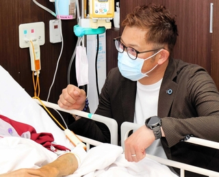 入院患者と交流する岩田稔さん＝兵庫県立尼崎総合医療センター