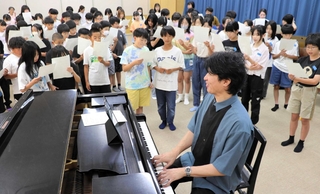 作曲した足立知謙さんの指導を受けながら歌う児童たち＝尼崎市杭瀬北新町２