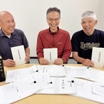 参考にした史料を前に、完成した甲東村誌稿本を手にする甲東文化財保存会メンバー＝西宮市甲東園３