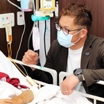 入院患者と交流する岩田稔さん＝兵庫県立尼崎総合医療センター