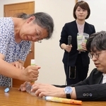 エピペンの打ち方を参加者（左）に教える医師の平瀬敏志さん（右）＝西宮市六湛寺町
