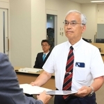 猪名川町長選で再選され、当選証書を受け取る岡本信司氏（右）＝猪名川町役場