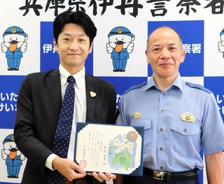 丸山文勝伊丹署長（右）からのじぎく賞を伝達された真野宏晃さん＝伊丹市千僧１