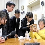 阪神大空襲を経験した３姉妹の三女、柏原佐紀子さん（右から２人目）の語りに耳を傾ける放送部員ら＝鳴尾高校