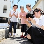 橋がこの場所にある最後の８月６日。阪神大空襲を経験した３姉妹と一緒に手を合わせる（手前右から）山口伊織さんと三木さゆりさん＝西宮市学文殿町