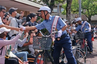 自転車にまたがり町民らと交流するアキナの山名文和さん（左）と秋山賢太さん